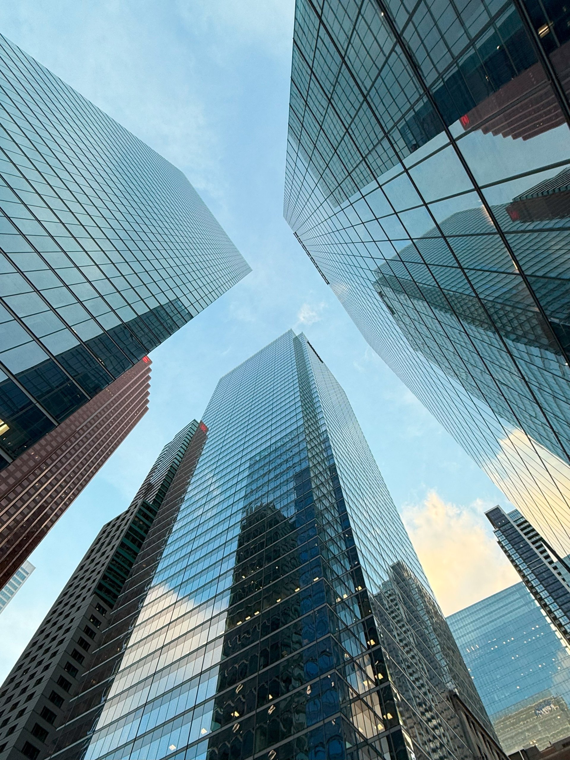 Modern glass skyscrapers reflecting city skyline representing corporate real estate investment growth